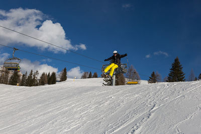 Man skiing on snow covered mountain against sky