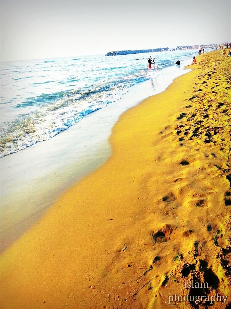 sea, beach, sand, water, shore, horizon over water, scenics, beauty in nature, tranquility, tranquil scene, vacations, wave, nature, clear sky, surf, incidental people, coastline, idyllic, tourism