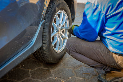 Low section of man fixing tire