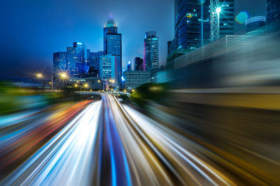 Light trails on illuminated city buildings at night