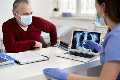 Doctor examining x-ray image sitting at medical clinic