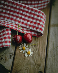 Two red cherries on a wooden table