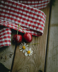 Two red cherries on a wooden table