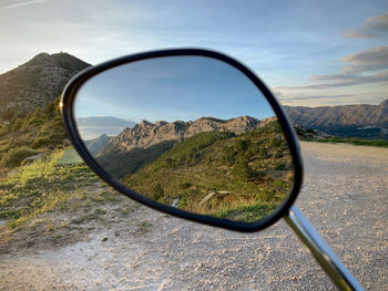 Reflection of mountains on side-view mirror