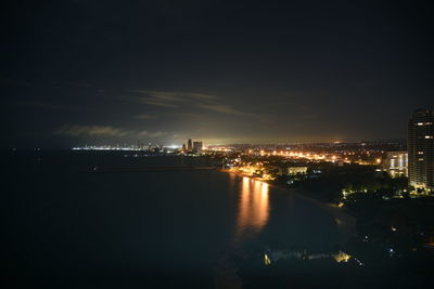 High angle view of illuminated buildings by river against sky at night