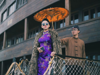 Woman standing against building in city
