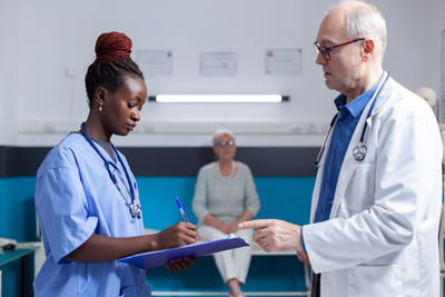 Smiling female doctor holding hands