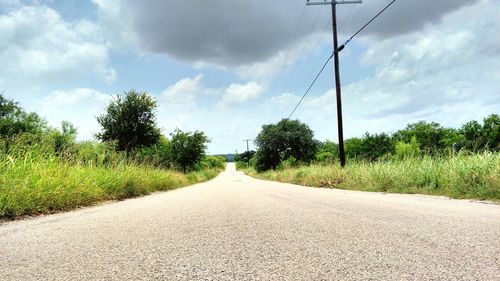Country road against cloudy sky