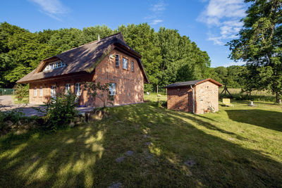 House amidst trees and buildings against sky