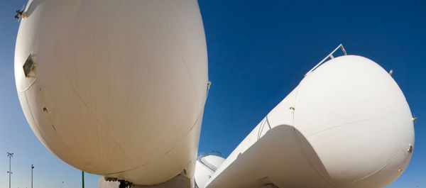 Low angle view of airplane flying against clear blue sky