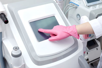 Cropped hand of person holding button in clinic