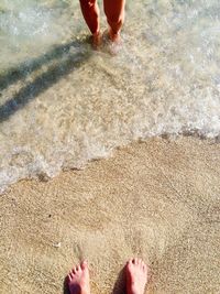 Low section of people standing on beach