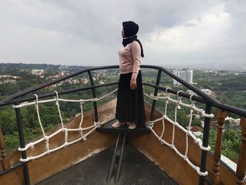 Side view of woman wearing hijab standing on observation point