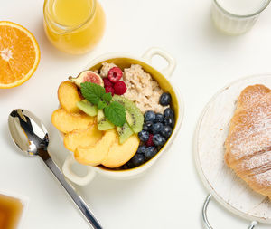 Plate with oatmeal and fruit, half a ripe orange and freshly squeezed juice in a transparent glass 