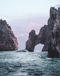 Rock formations in sea against sky