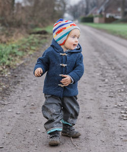 Full length of cute girl walking on dirt road