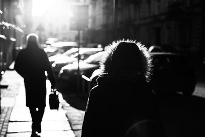 Rear view of women walking on street during winter