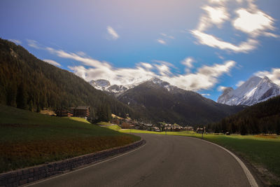 Road by mountains against sky