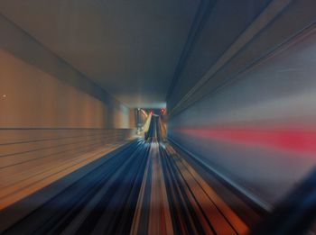 Blurred motion of escalator in illuminated tunnel