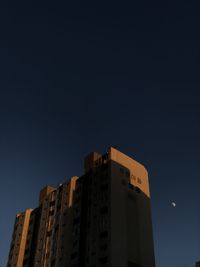 Low angle view of buildings against clear sky at night