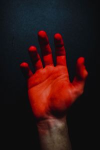 Close-up of hand touching red light