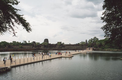 Temple and bridge over water against sky