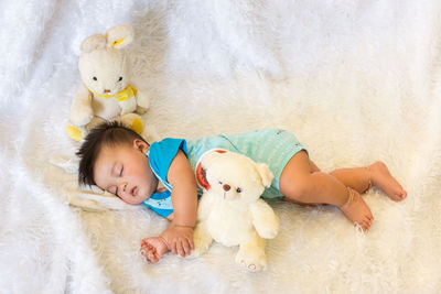 High angle view of baby lying on bed