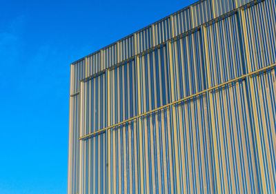 Low angle view of metallic structure against blue sky