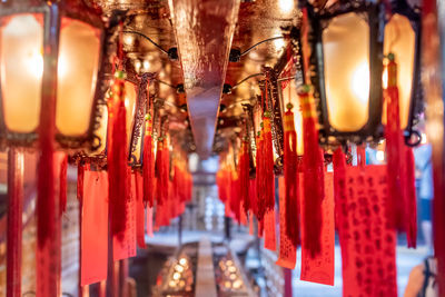 Illuminated lanterns hanging in temple outside building