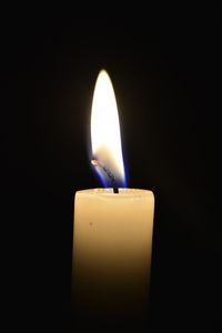 Close-up of illuminated candle against black background