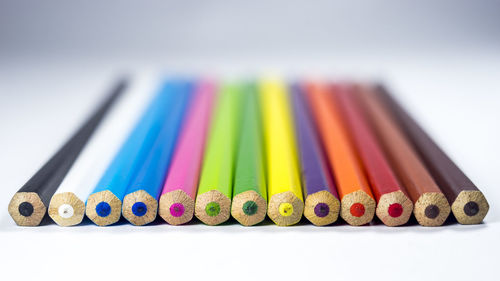 Close-up of colored pencils over white background