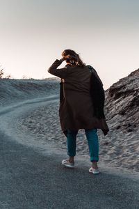 Full length of woman walking on road against sky