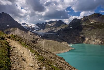 Scenic view of lake by mountains against sky