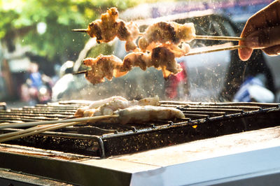 Person preparing food on barbecue grill