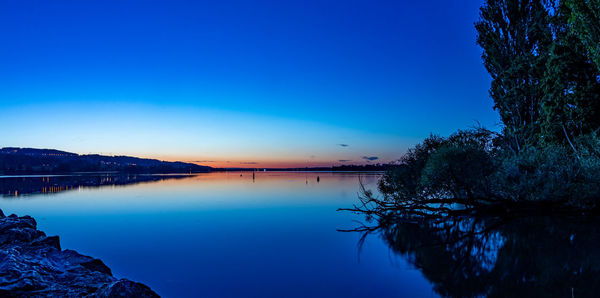 Scenic view of lake against clear blue sky