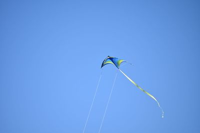 Low angle view of kite flying against clear blue sky