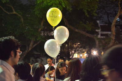 People with balloons against trees