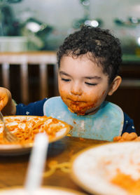 Boy having food on table at home