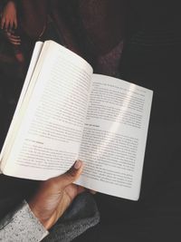 Midsection of person reading book