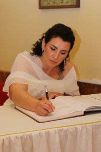 Young woman sitting on table at home