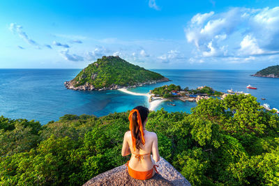 Woman looking at sea against sky