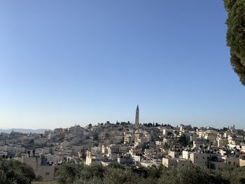 Buildings in city against clear blue sky