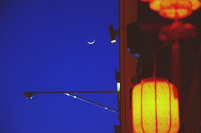 Low angle view of illuminated street light against sky