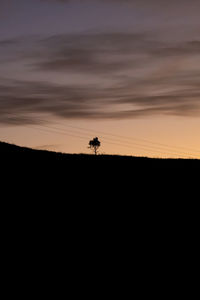 Scenic view of silhouette field against sky during sunset