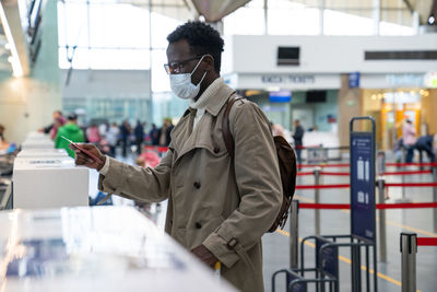 Side view of man using mobile phone in bus