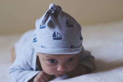 Cute baby boy lying on bed at home