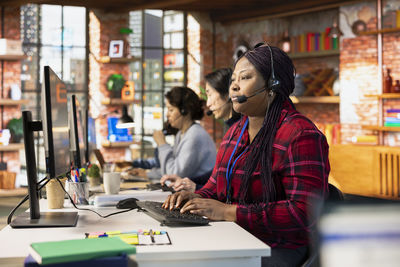 Side view of man using mobile phone in office
