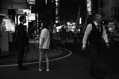 People walking on street in city at night