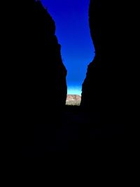 Silhouette rock formations against blue sky