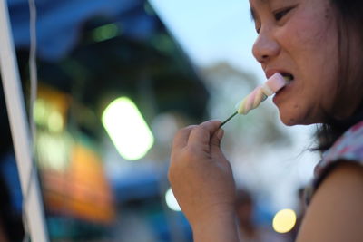 Close-up of girl eating marshmallow outdoors